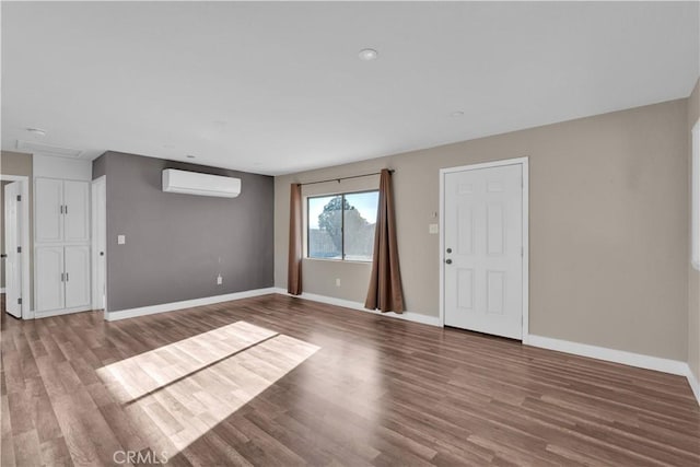 17908 Birch St, Hesperia, CA 92345 - unfurnished living room with wood finished floors, baseboards, and an AC wall unit