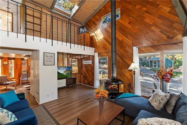 31867 Wagon Wheel Dr, Running Springs, CA 92382 - living area featuring high vaulted ceiling, wooden walls, wood finished floors, a wood stove, and a skylight