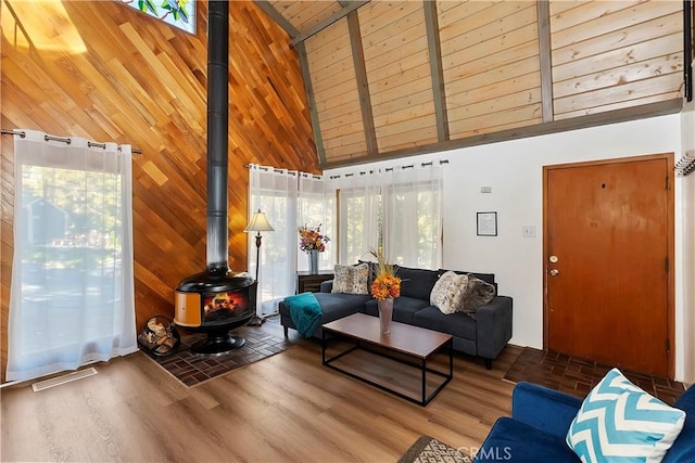 31867 Wagon Wheel Dr, Running Springs, CA 92382 - living area featuring a wood stove, high vaulted ceiling, wood walls, wood finished floors, and wood ceiling