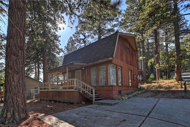 31867 Wagon Wheel Dr, Running Springs, CA 92382 - view of front of home with roof with shingles, a gambrel roof, and covered porch