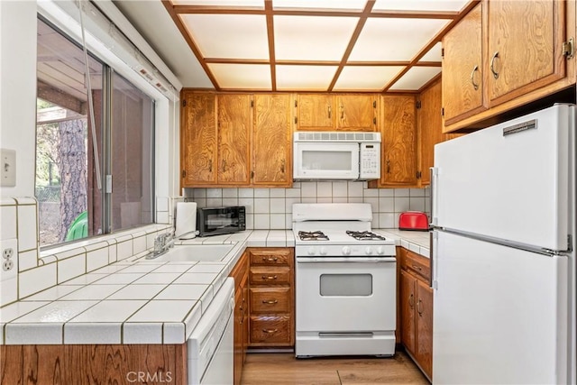31867 Wagon Wheel Dr, Running Springs, CA 92382 - kitchen with white appliances, tile counters, brown cabinets, and backsplash