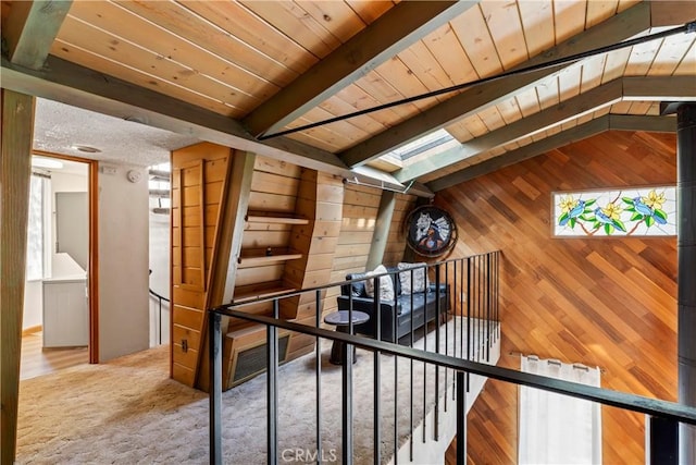 31867 Wagon Wheel Dr, Running Springs, CA 92382 - corridor featuring wooden walls, an upstairs landing, carpet floors, and a wooden ceiling with exposed beams