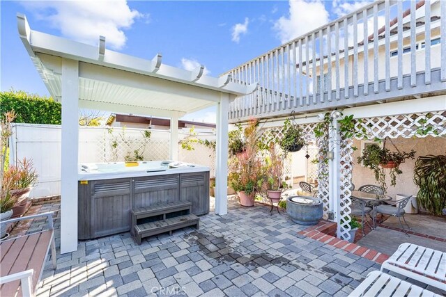view of patio with a pergola, fence, and a hot tub