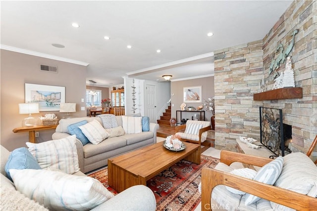 living room featuring a stone fireplace, ornamental molding, recessed lighting, stairway, and visible vents