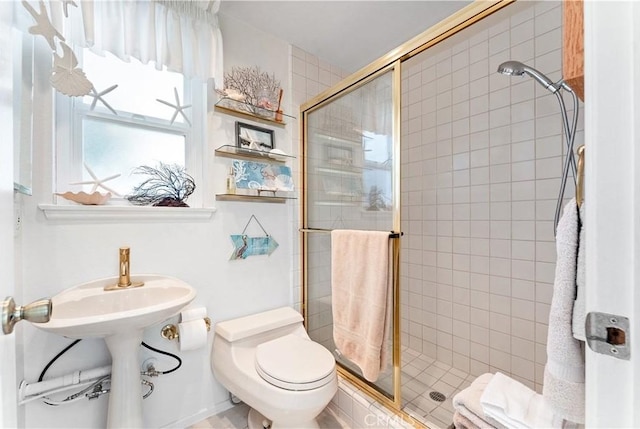bathroom featuring toilet and a shower stall