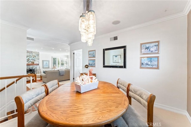 dining room featuring baseboards, a chandelier, carpet flooring, crown molding, and visible vents