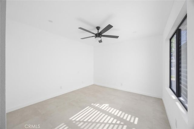 spare room with baseboards and ceiling fan