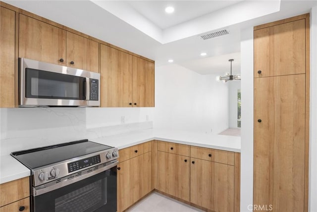 1910 Grand Bahama Dr E, Palm Springs, CA 92264 - kitchen featuring appliances with stainless steel finishes, light countertops, a chandelier, and recessed lighting