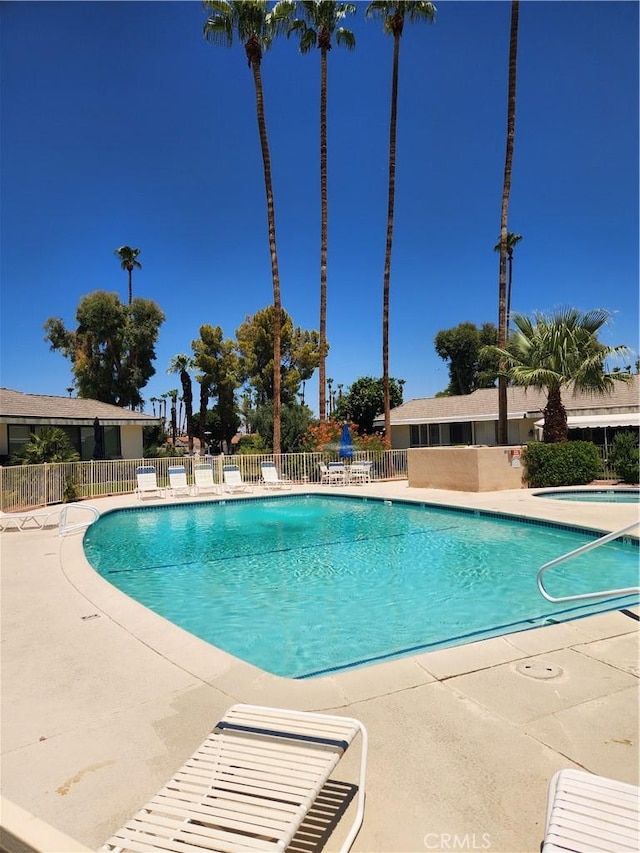 pool featuring fence and a patio