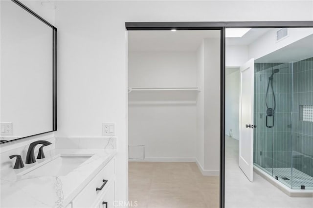 full bath with visible vents, vanity, a walk in closet, tile patterned floors, and a shower stall