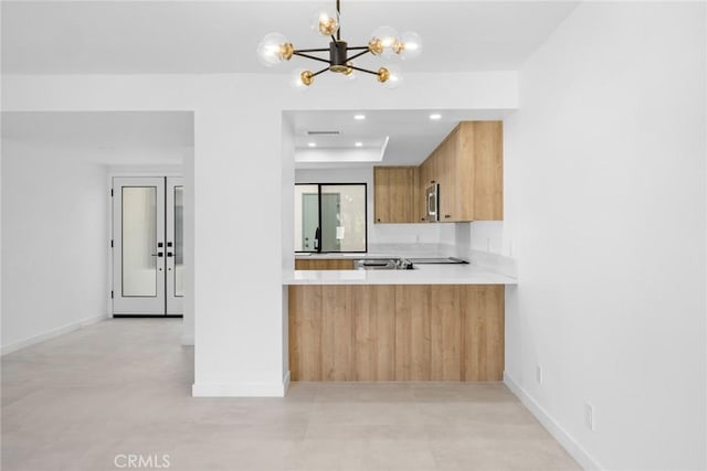 1910 Grand Bahama Dr E, Palm Springs, CA 92264 - kitchen featuring a chandelier, light countertops, stainless steel microwave, finished concrete floors, and a sink