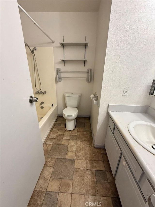 72183 Sunnyvale Dr Unit 29, Palms, CA 92277 - bathroom with stone tile floors, baseboards, vanity, toilet, and bathing tub / shower combination