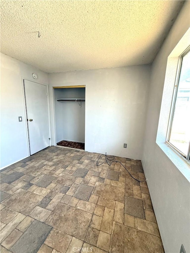 72183 Sunnyvale Dr Unit 29, Palms, CA 92277 - unfurnished bedroom with a closet, a textured ceiling, and stone finish flooring
