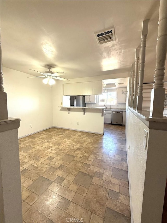 72183 Sunnyvale Dr Unit 29, Palms, CA 92277 - kitchen featuring appliances with stainless steel finishes, a breakfast bar area, ceiling fan, a peninsula, and baseboards