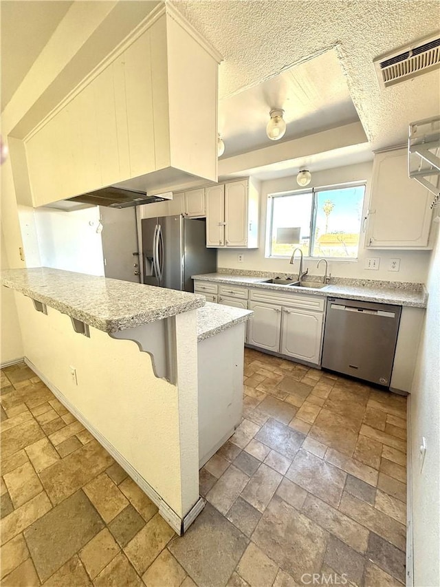 72183 Sunnyvale Dr Unit 29, Palms, CA 92277 - kitchen featuring stainless steel appliances, a sink, stone tile floors, a textured ceiling, and light stone countertops