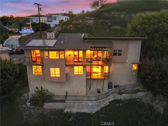 5084 Llano Dr, Woodland Hills, CA 91364 - back of property with a balcony, solar panels, stucco siding, central AC unit, and a patio area
