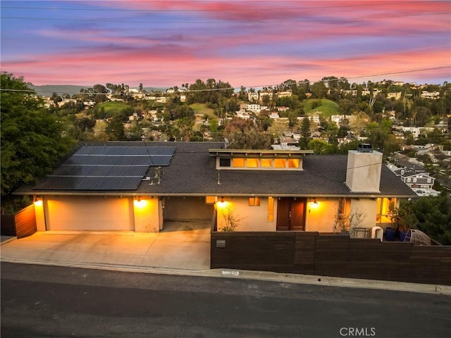 5084 Llano Dr, Woodland Hills, CA 91364 - view of front of home featuring a fenced front yard, solar panels, concrete driveway, an attached garage, and a chimney