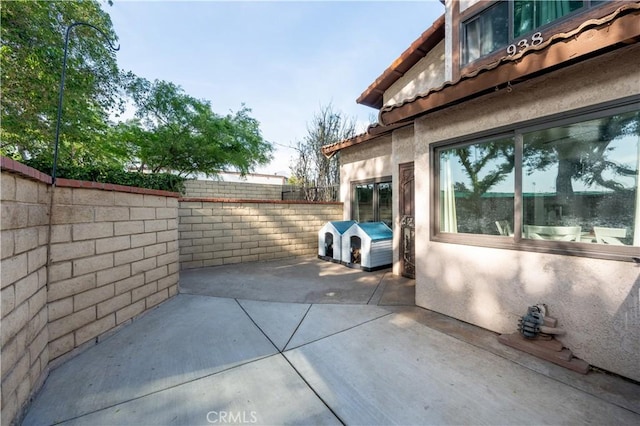 view of home's exterior featuring a tiled roof, a fenced backyard, a patio area, and stucco siding