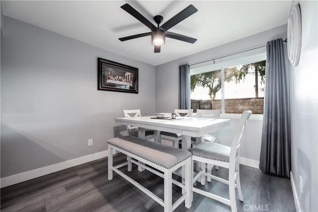 dining area featuring dark wood-type flooring, baseboards, and ceiling fan