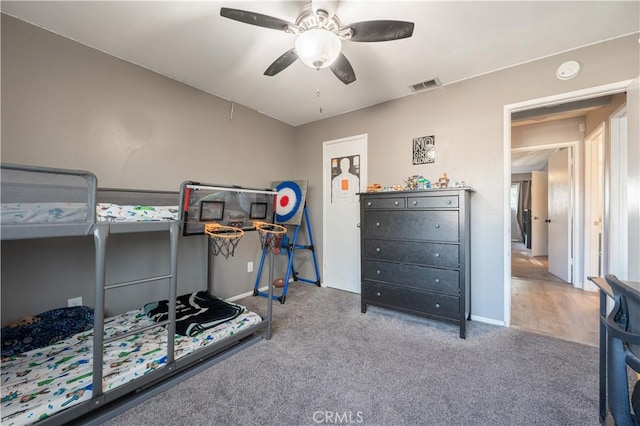 carpeted bedroom with visible vents and a ceiling fan