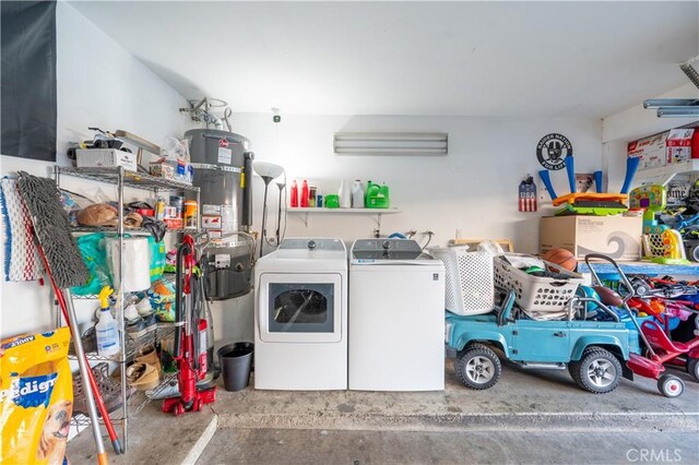 clothes washing area with strapped water heater, laundry area, and washing machine and clothes dryer