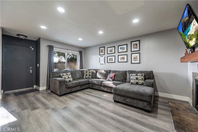 living area featuring wood finished floors, baseboards, and recessed lighting
