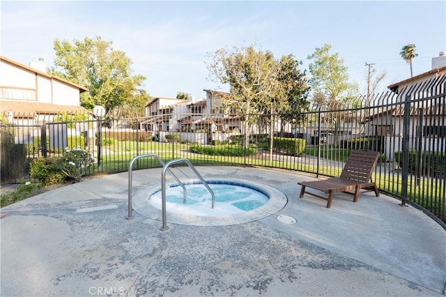 view of swimming pool featuring a residential view, fence, and a hot tub