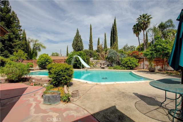 view of swimming pool featuring a water slide, a fenced in pool, a patio, and a fenced backyard