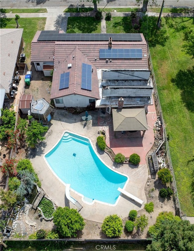 outdoor pool with a diving board and a patio