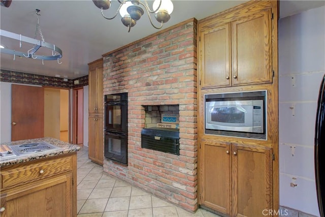 kitchen with stainless steel microwave, a chandelier, light tile patterned floors, dobule oven black, and electric stovetop