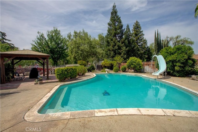 pool with a fenced backyard, a water slide, a gazebo, and a patio