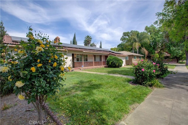single story home featuring stucco siding, solar panels, a chimney, and a front yard