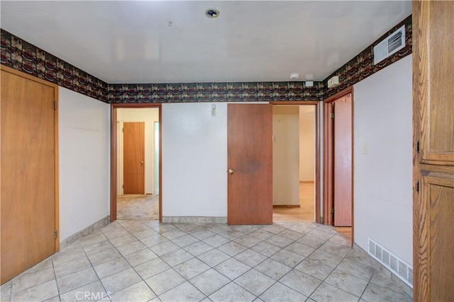 unfurnished room with visible vents and light tile patterned flooring