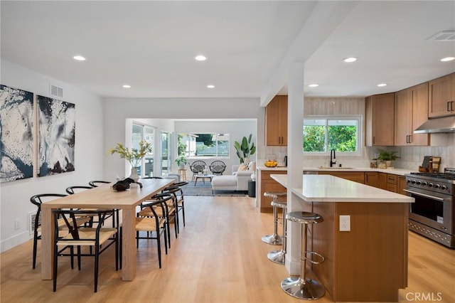 3130 E Craig Dr, Orange, CA 92869 - kitchen featuring high end stainless steel range oven, under cabinet range hood, decorative backsplash, light countertops, and a center island