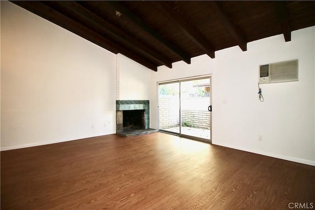 unfurnished living room with a wall mounted AC, wood ceiling, wood finished floors, a large fireplace, and vaulted ceiling with beams
