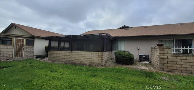 643 W Villa Chaparral Rd, San Jacinto, CA 92583 - view of side of home with a yard, central AC, a sunroom, and stucco siding