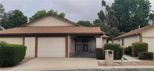 643 W Villa Chaparral Rd, San Jacinto, CA 92583 - view of front of house featuring an attached garage, a shingled roof, and driveway