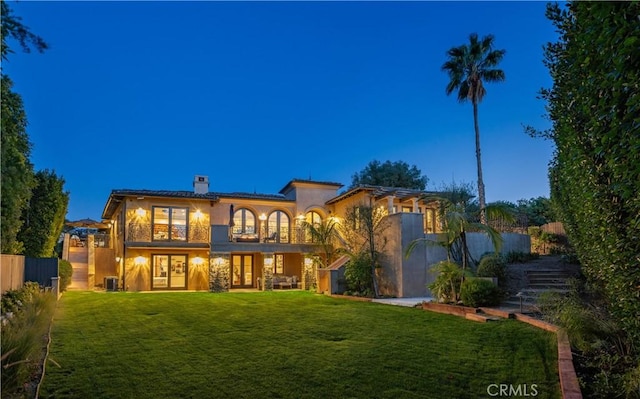 1217 Granvia Altamira, Palos Verdes Estates, CA 90274 - rear view of house with french doors, stucco siding, fence, and a lawn