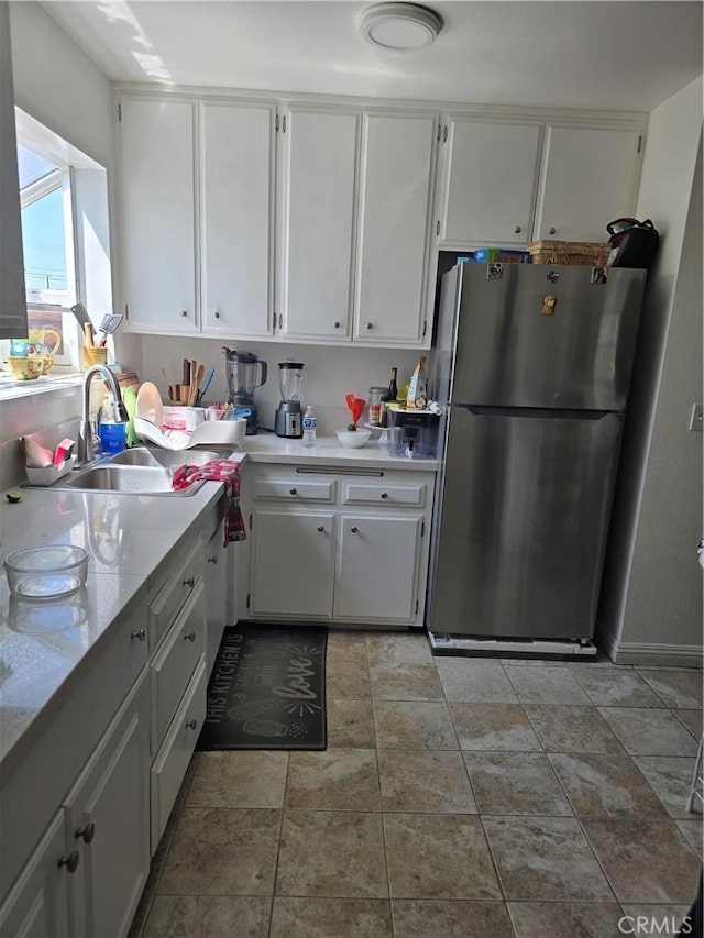 1861 N Lilac Ave, Rialto, CA 92376 - kitchen with a sink, light countertops, white cabinets, and freestanding refrigerator