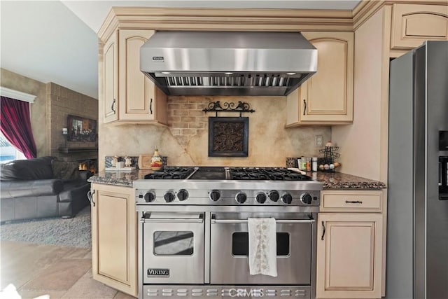 kitchen with wall chimney exhaust hood, cream cabinetry, and stainless steel appliances