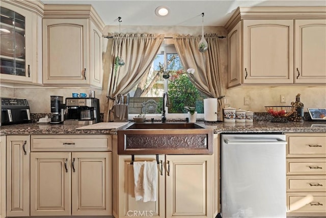 kitchen with dishwasher, a sink, and cream cabinets