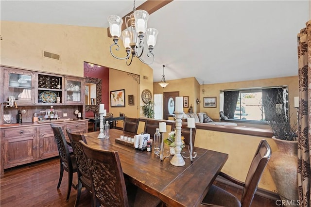dining room with dark wood finished floors, vaulted ceiling, a notable chandelier, and visible vents