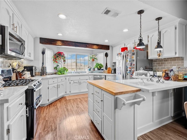 13250 Yellowstone Ave, Victorville, CA 92395 - kitchen featuring visible vents, wooden counters, light wood-style floors, and stainless steel appliances
