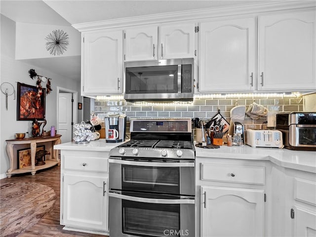 13250 Yellowstone Ave, Victorville, CA 92395 - kitchen featuring tasteful backsplash, white cabinetry, wood finished floors, light countertops, and stainless steel appliances