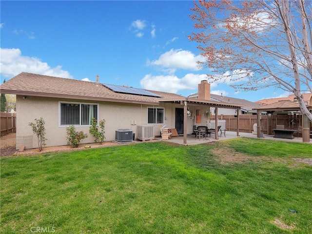 13250 Yellowstone Ave, Victorville, CA 92395 - rear view of house with central AC, a fenced backyard, stucco siding, a patio, and solar panels