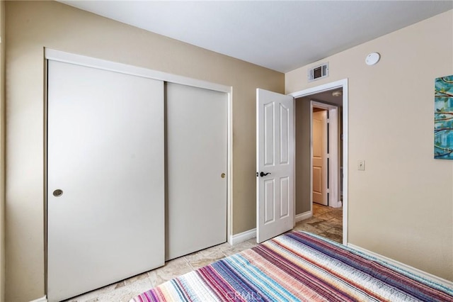 unfurnished bedroom featuring visible vents, baseboards, and a closet