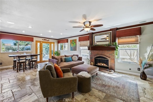 living area featuring crown molding, baseboards, a ceiling fan, and stone tile floors