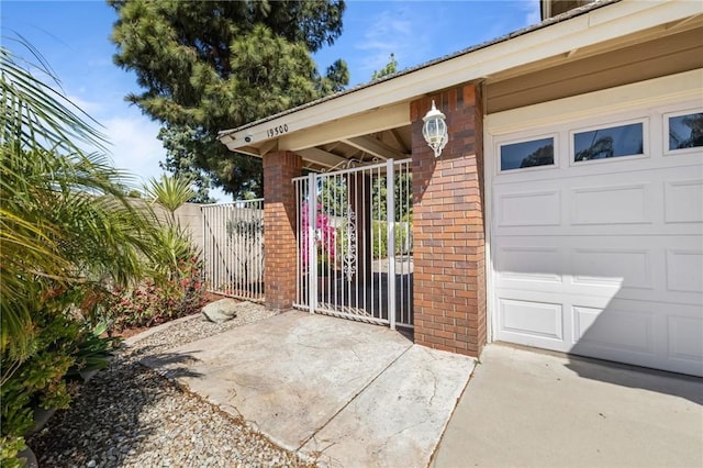doorway to property featuring brick siding and fence
