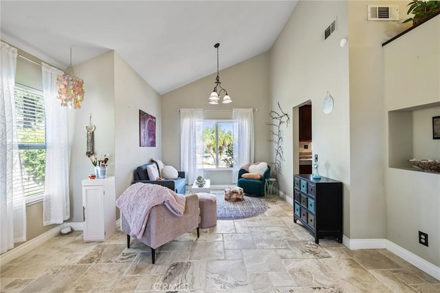 living area with stone tile flooring, an inviting chandelier, baseboards, and visible vents