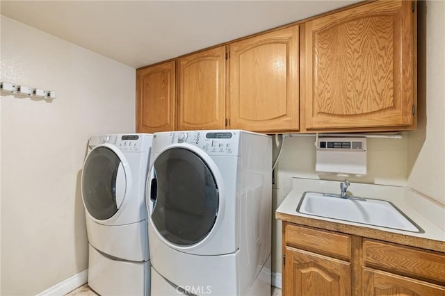 laundry room featuring baseboards, independent washer and dryer, a sink, and cabinet space